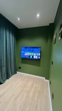 Dnevna soba sa zelenim zidovima i televizorom. - image 2