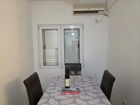 Trpezarija sa stolom, stolicama i klima uređajem na zidu. - image 5