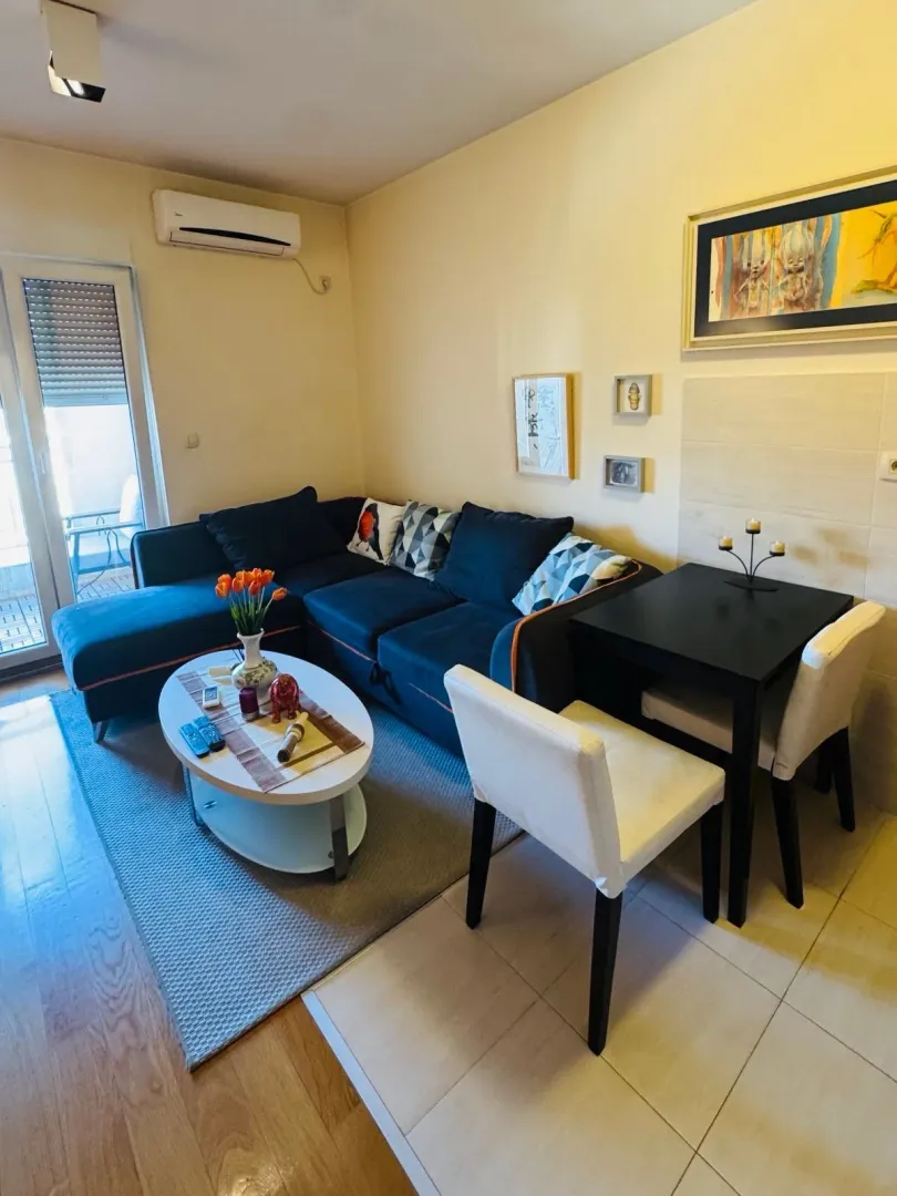 Living room with a sofa, coffee table and dining table.