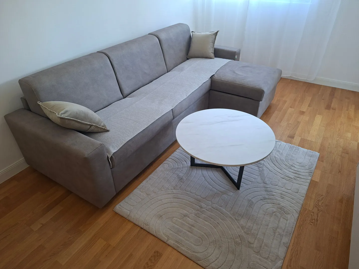 Living room with a sectional sofa, coffee table and rug.