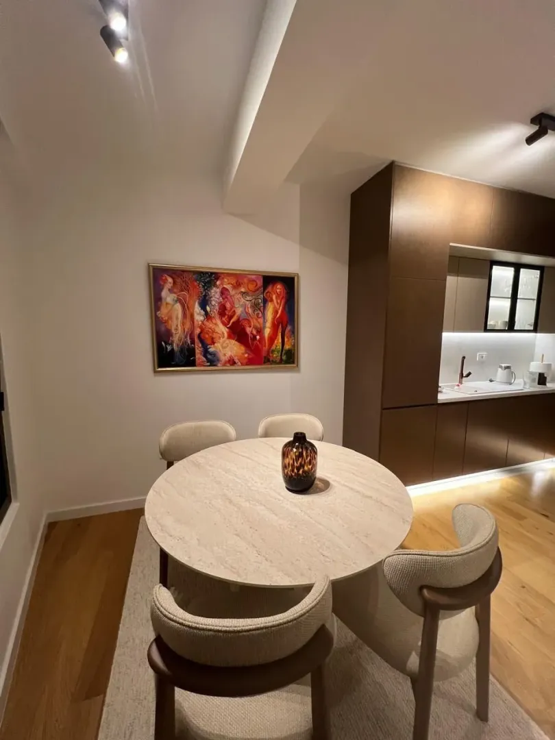 Dining area with a round table and chairs, overlooking part of the kitchen.
