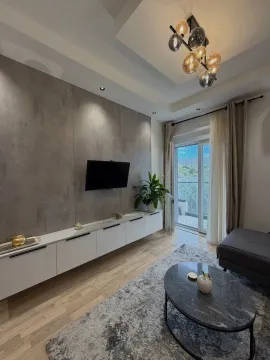Modern living room with TV, sofa, and terrace access. - image 12