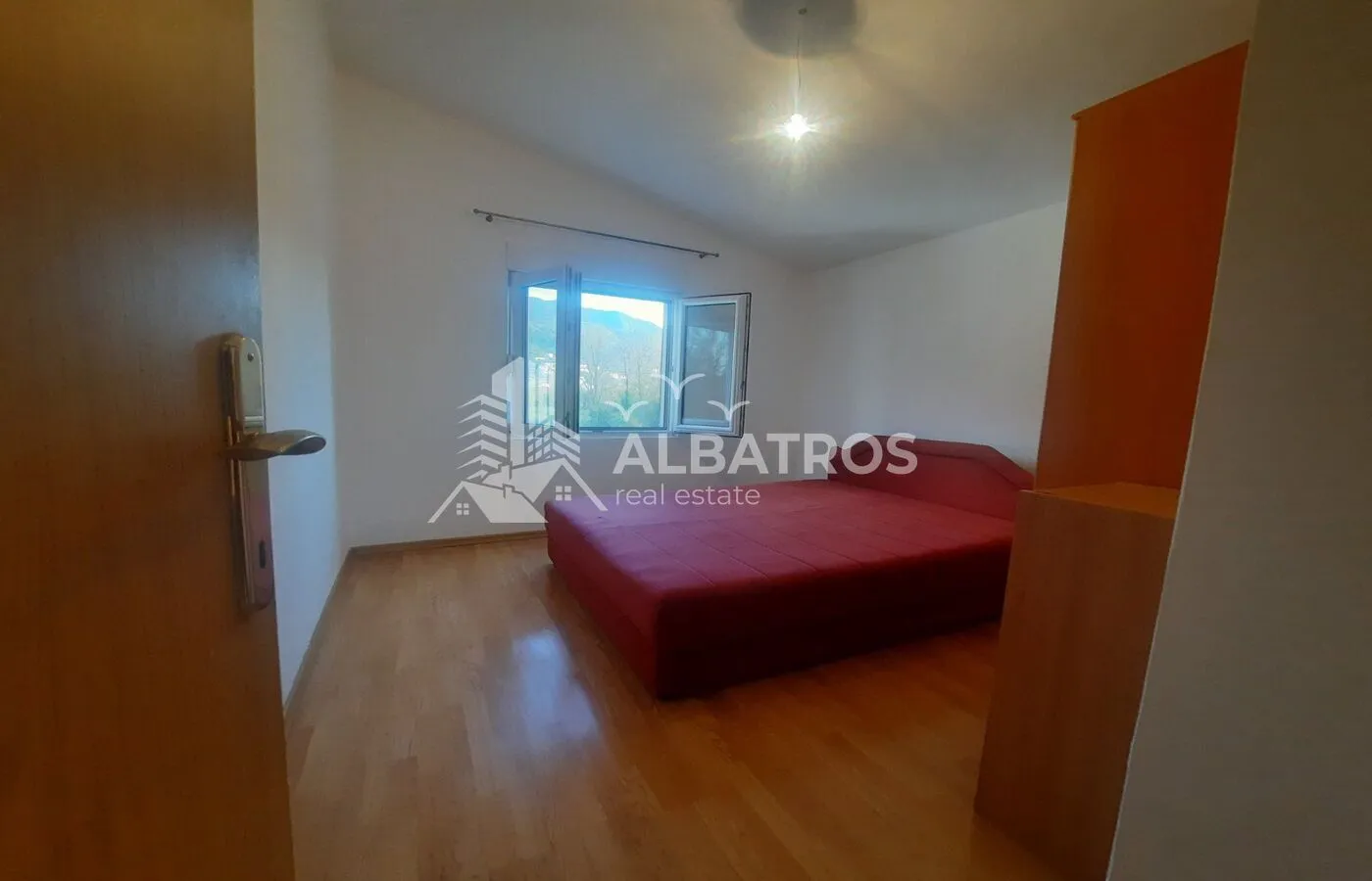 Bedroom with a double bed and a window overlooking nature.