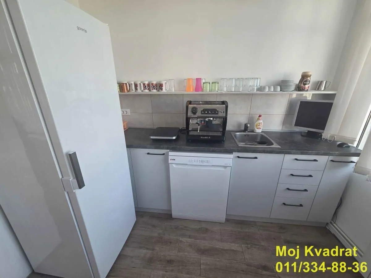 Small kitchen with white cabinets, a refrigerator, and a sink.
