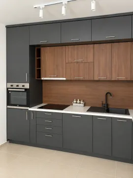 Modern kitchen with dark cabinets and wooden details. - image 10