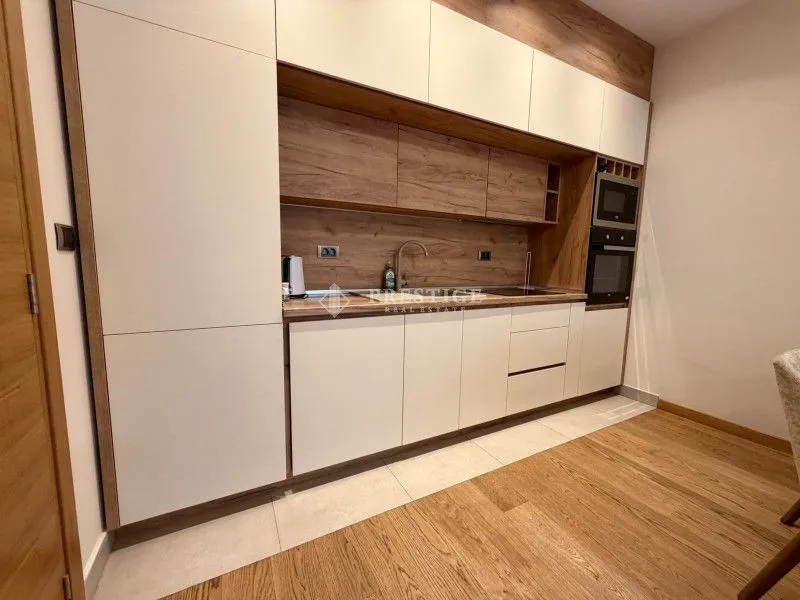Modern kitchen with white cabinets and wooden details.