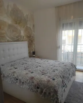 Furnished bedroom with a double bed and floral motif wallpaper. - image 3