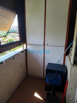 Natkriveni balkonski prostor sa ugrađenim ormarom i pogledom na okolinu. - image 7