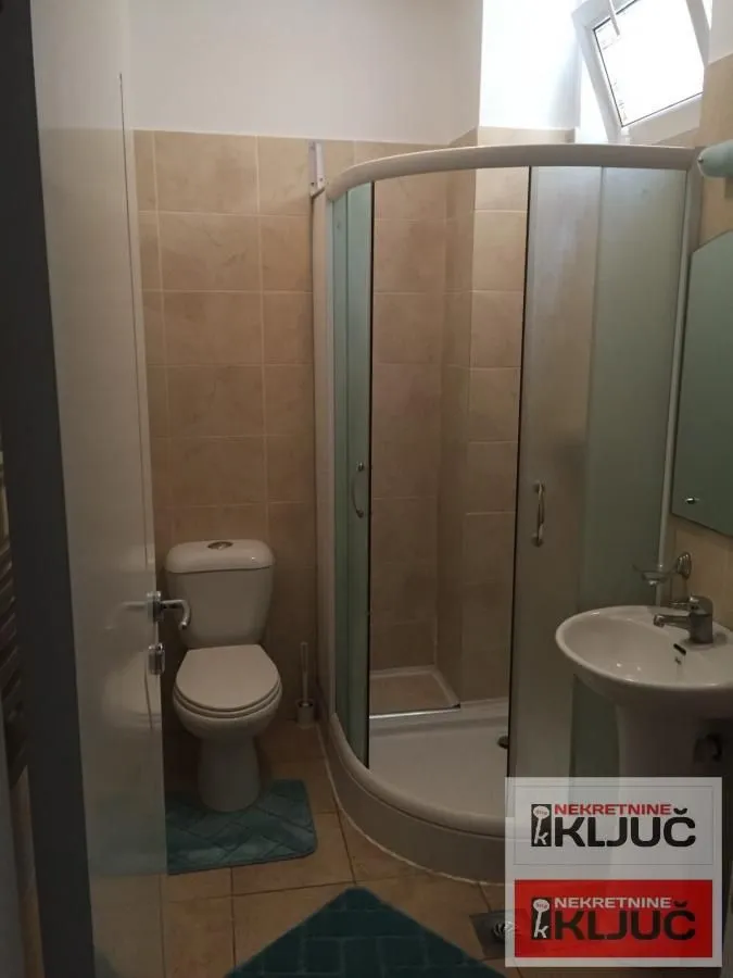 Kupatilo opremljeno tuš kabinom, umivaonikom i wc šoljom.