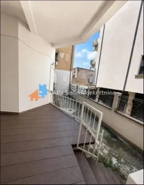 Covered terrace with wooden decking and a view of surrounding buildings. - image 9