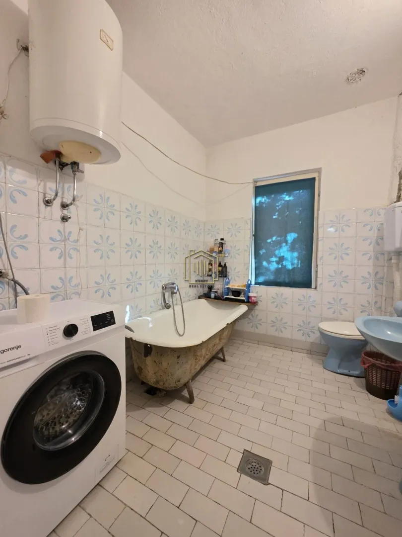 Kupatilo opremljeno kadom, umivaonikom, WC šoljom i mašinom za veš.