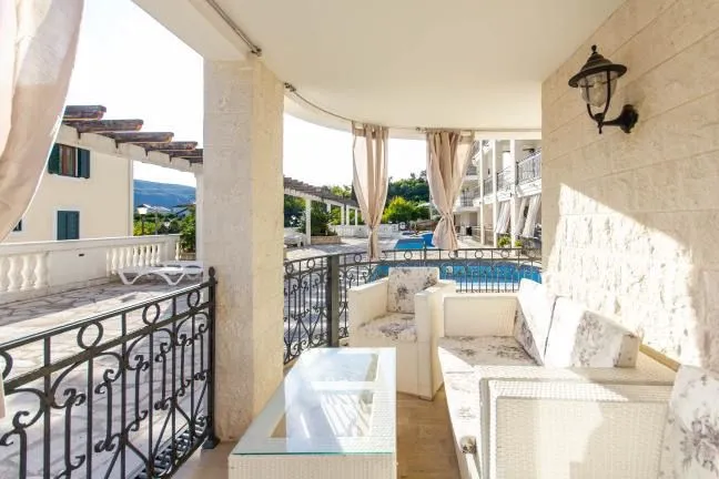 Covered terrace with seating furniture and a view of the pool.