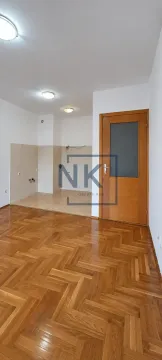 Prazna kuhinja sa pločicama na zidu i drvenim podom. - image 3