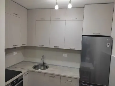 Modern kitchen with light cabinetry and a refrigerator. - image 3