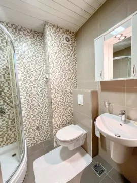 Svijetlo i moderno kupatilo sa tuš kabinom, umivaonikom i toaletom. - image 2