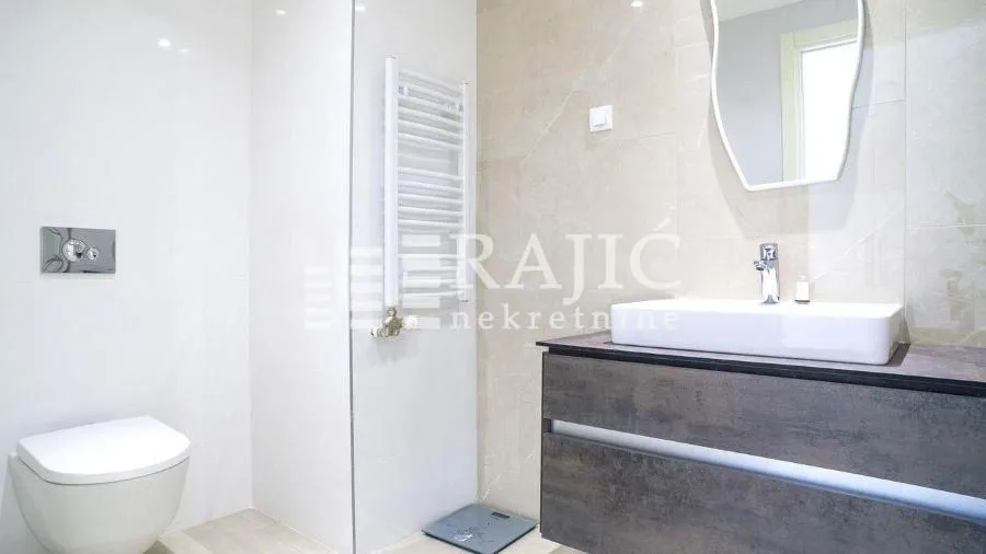 Modern bathroom with washbasin, toilet, and shower cabin.