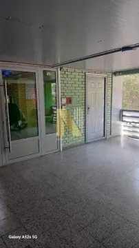 Building entrance with tiled floor and green wall cladding. - image 5