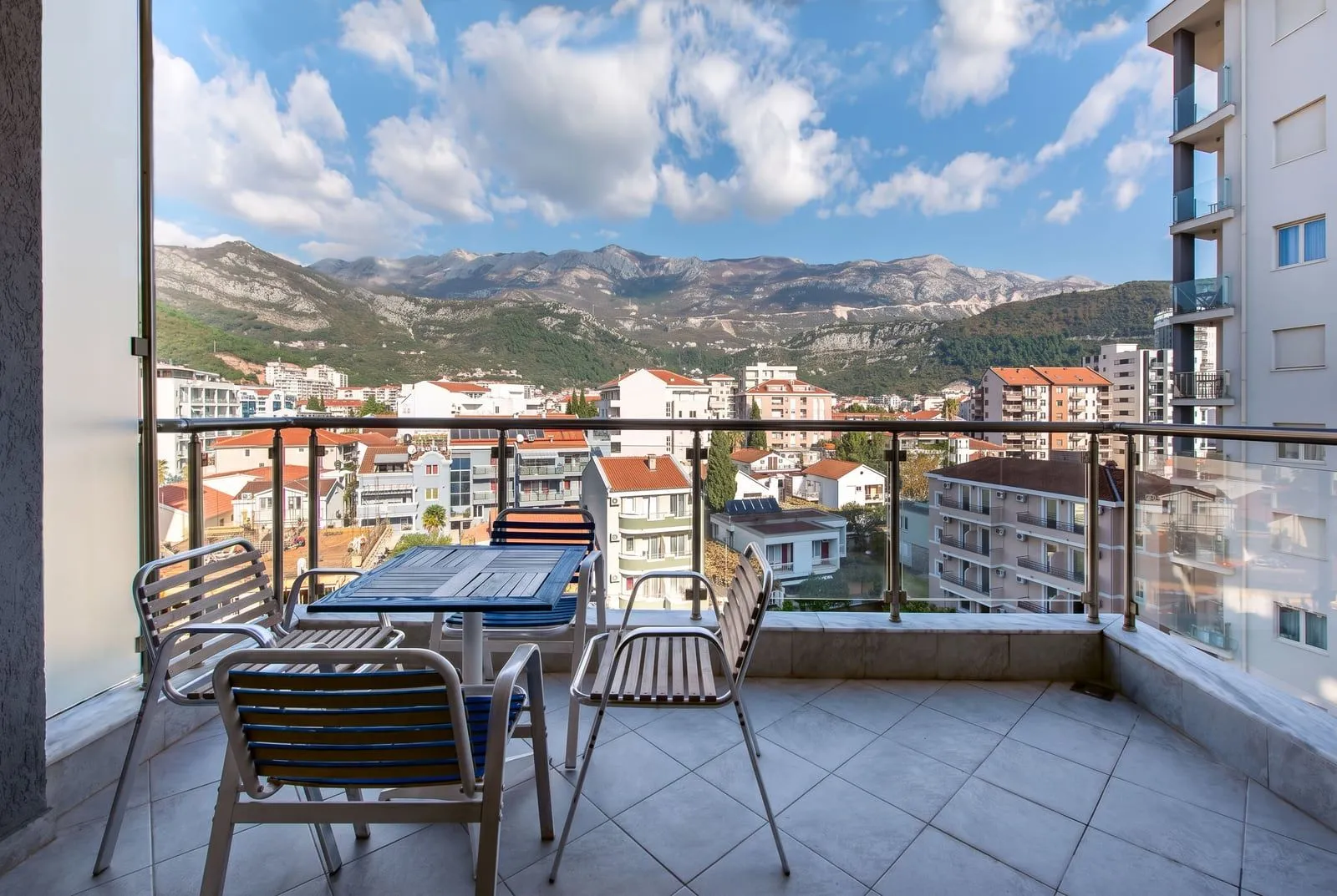 Namješten balkon sa garniturom za sjedenje i pogledom na grad i planine.