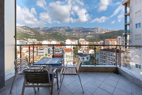 Namješten balkon sa garniturom za sjedenje i pogledom na grad i planine. - image 2