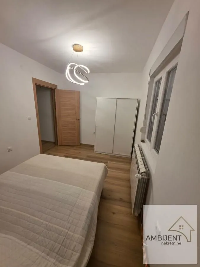 Furnished bedroom with a double bed, wardrobe, and wooden flooring.