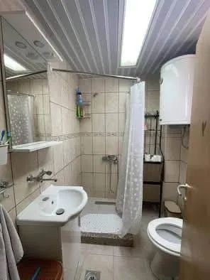 Manje kupatilo sa tuš kabinom, umivaonikom i wc šoljom.