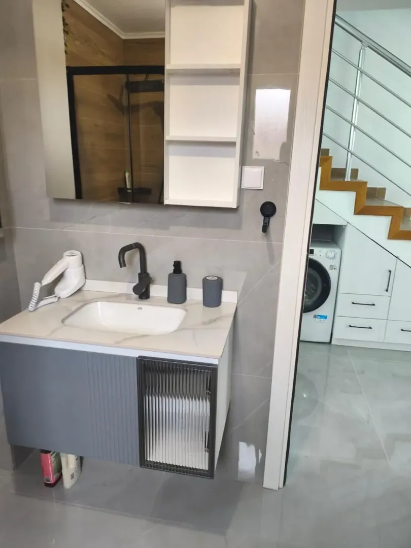 Modern bathroom equipped with a vanity unit and mirror.