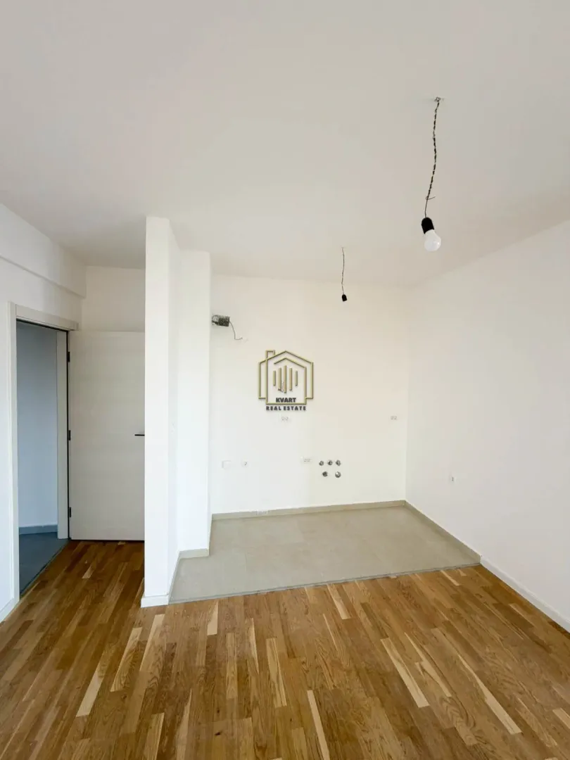 Empty space intended for a kitchen with connections and wooden flooring.