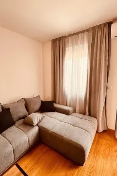 Dnevna soba sa ugaonom garniturom i prozorom sa zavjesama. - image 3
