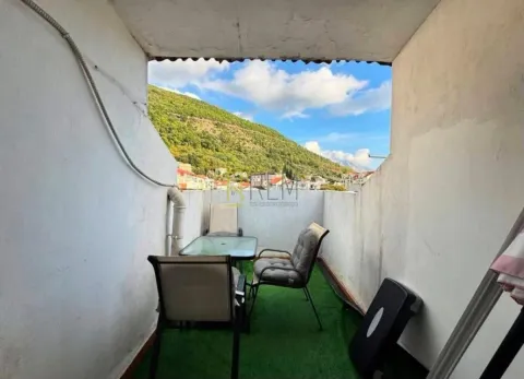 Small covered terrace with a table, chairs, and artificial grass. - image 10