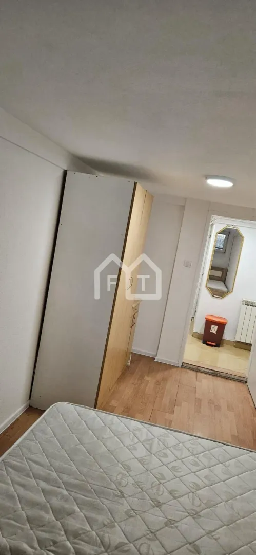 Small bedroom with a bed and a wardrobe.
