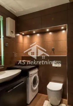 Bathroom equipped with sanitary ware, a sink, and a washing machine. - image 12