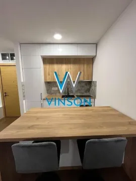 Moderna kuhinja sa drvenim elementima i šankom za ručavanje. - image 4