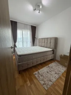 Bedroom with a double bed, parquet flooring, and a window with curtains. - image 4