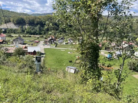 Pogled sa uzvišenja na zelenu parcelu i okolne kuće u naselju. - image 2