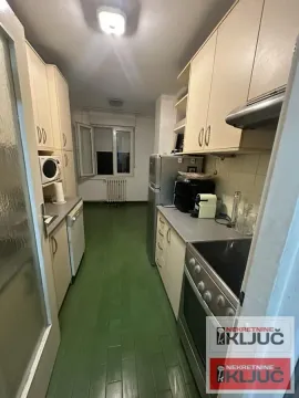 Manja kuhinja sa svetlim elementima i drvenim podom. - image 4