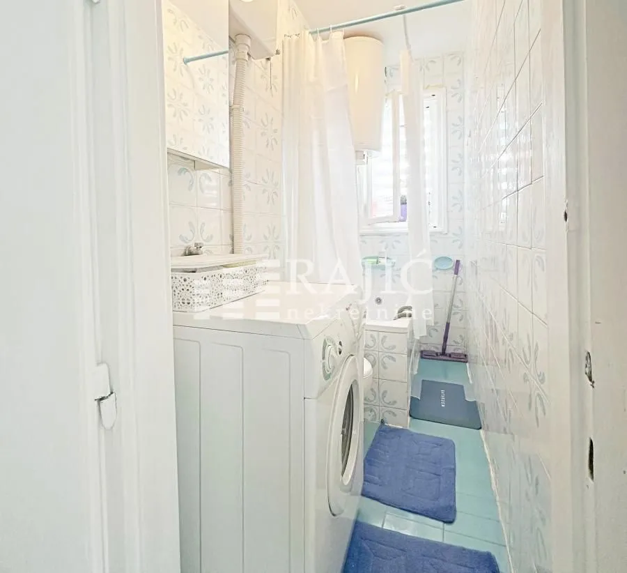 Smaller bathroom with a washing machine and a shower.
