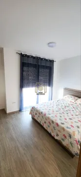 Bedroom with a double bed and a window with dark curtains. - image 5