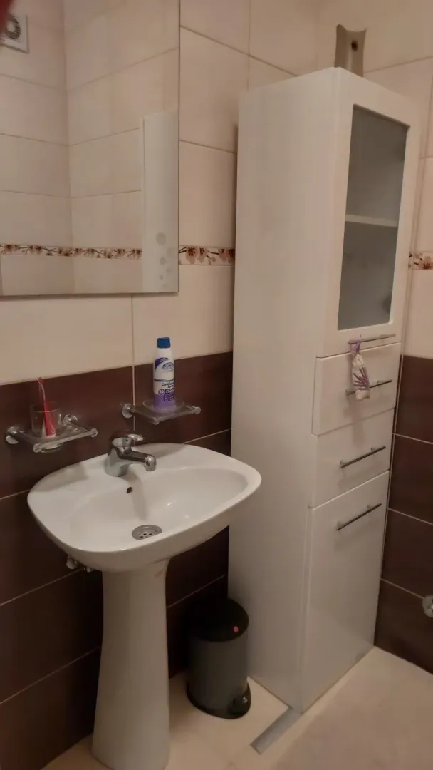 Small bathroom with a sink, mirror, and white cabinet.