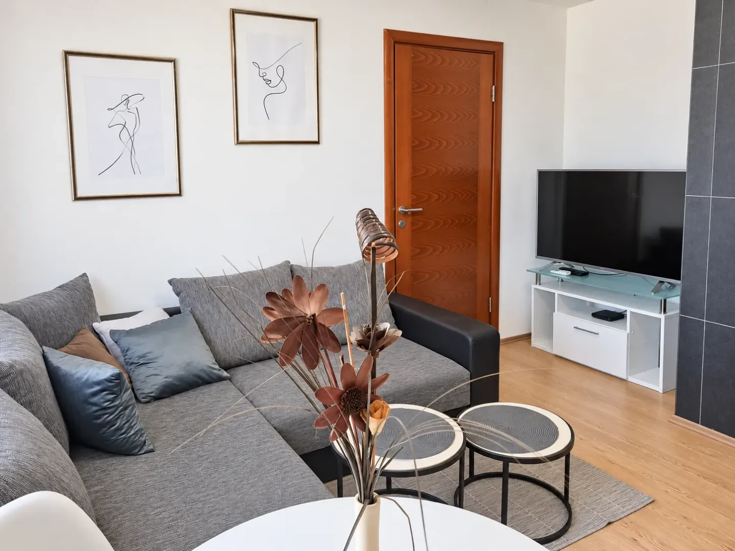 Living room with a sectional sofa, TV, and decorative details.