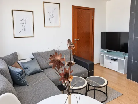 Living room with a sectional sofa, TV, and decorative details. - image 2