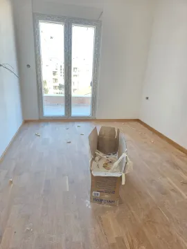 Prazna soba u izgradnji sa parketom i kutijom na podu. - image 8
