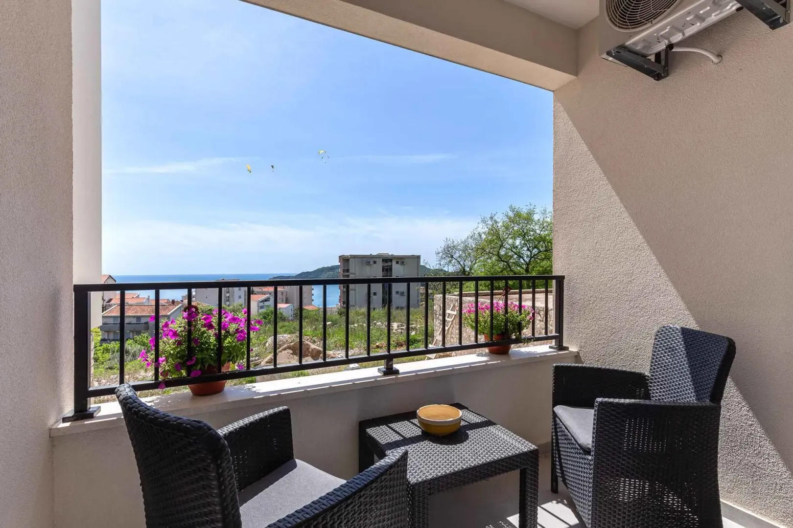 Namješten balkon sa garniturom za sjedenje i pogledom na more.