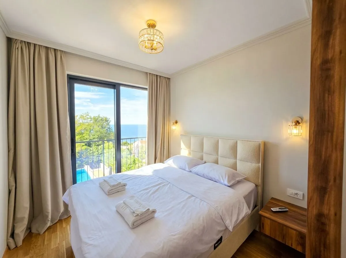 Bedroom with a double bed and access to a balcony with a sea view.