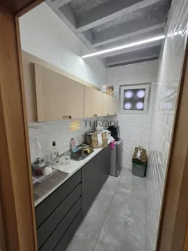 Small kitchen with a sink, cabinets, and white wall tiles. - image 14