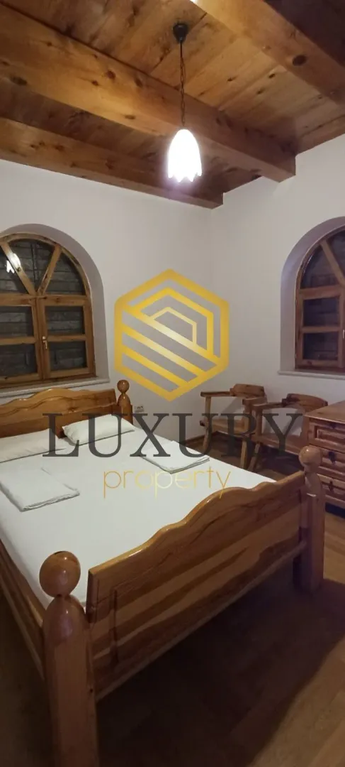 Bedroom with a wooden bed and ceiling.