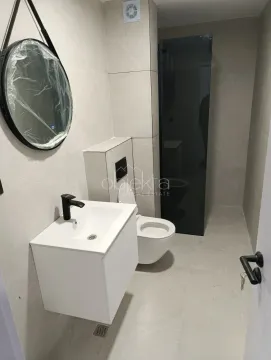 Savremeno opremljeno kupatilo sa umivaonikom, WC šoljom i ogledalom. - image 9
