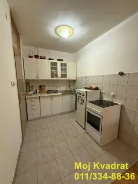 Manja kuhinja sa belim elementima, frižiderom i šporetom. - image 4
