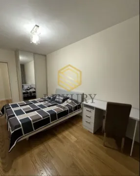 Furnished bedroom with a bed, desk, and mirrored wardrobe. - image 8