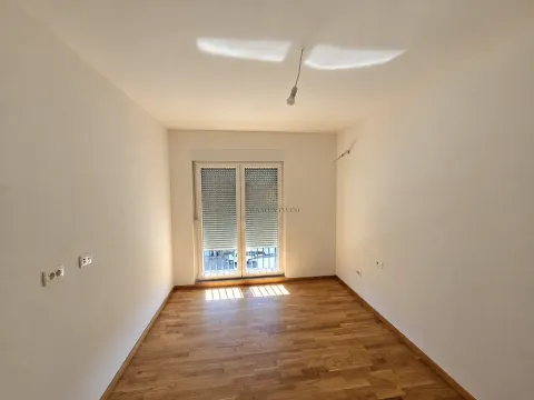 Prazna neopremljena prostorija sa drvenim podom i balkonskim vratima. - image 10