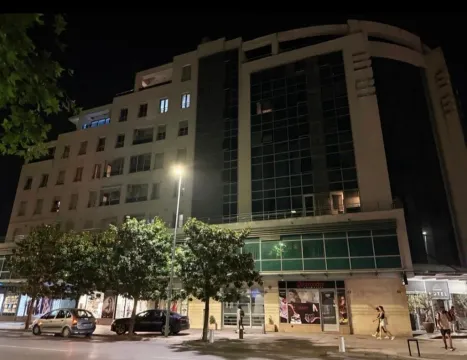 Noćni prikaz fasade stambeno-poslovne zgrade sa ulicom u prvom planu. - image 9